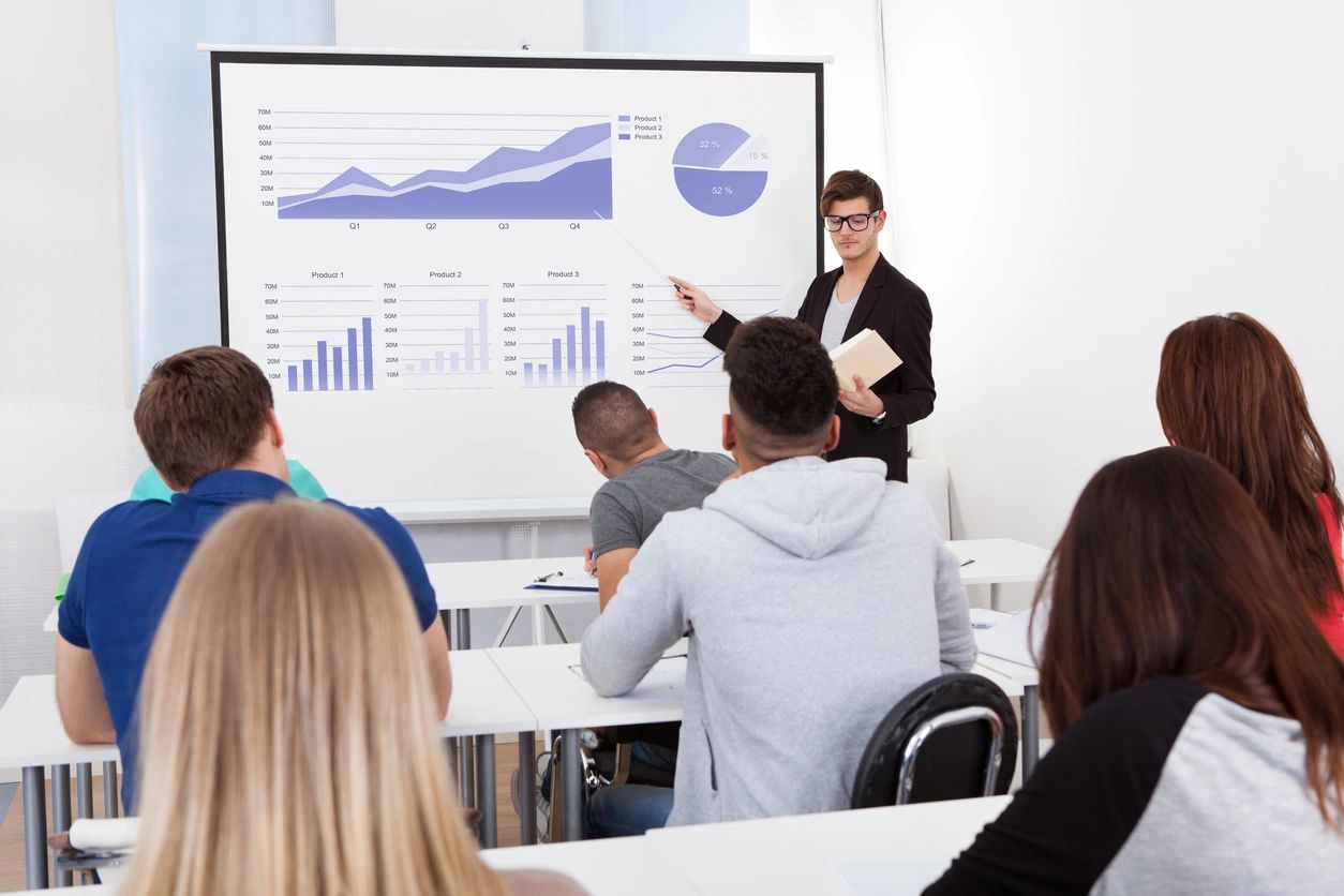 A woman standing in front of a class giving a presentation.